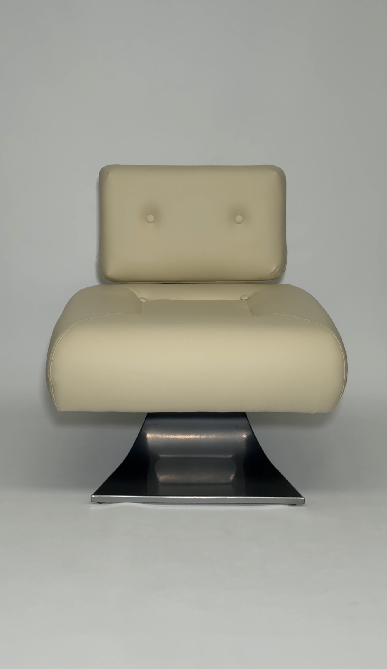 Butter-yellow lounge chair with chrome curved base.