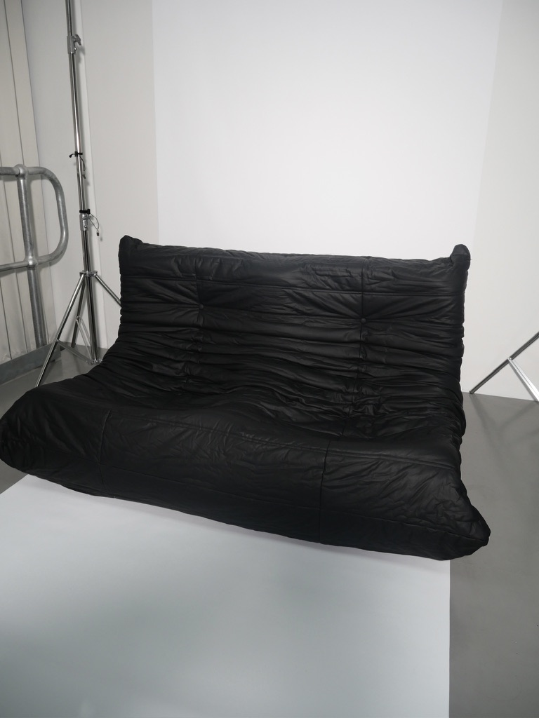 Soft black slouch couch — low and inviting.