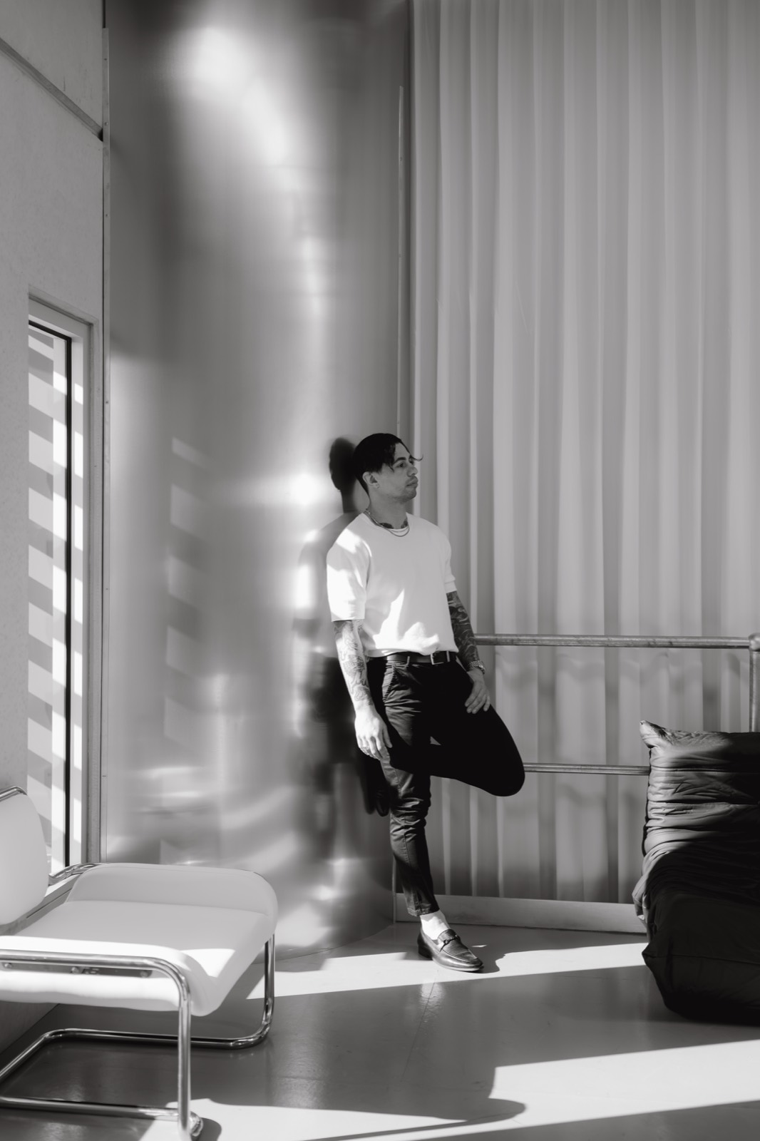 Black and white motion frame of a model by the window and daybed in the light-filled studio.